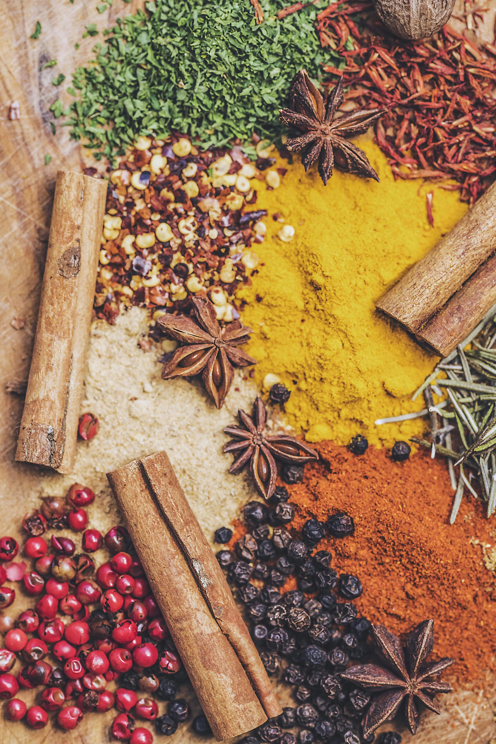 Colourful ground spices, cinnamon and star anise on a wooden surface