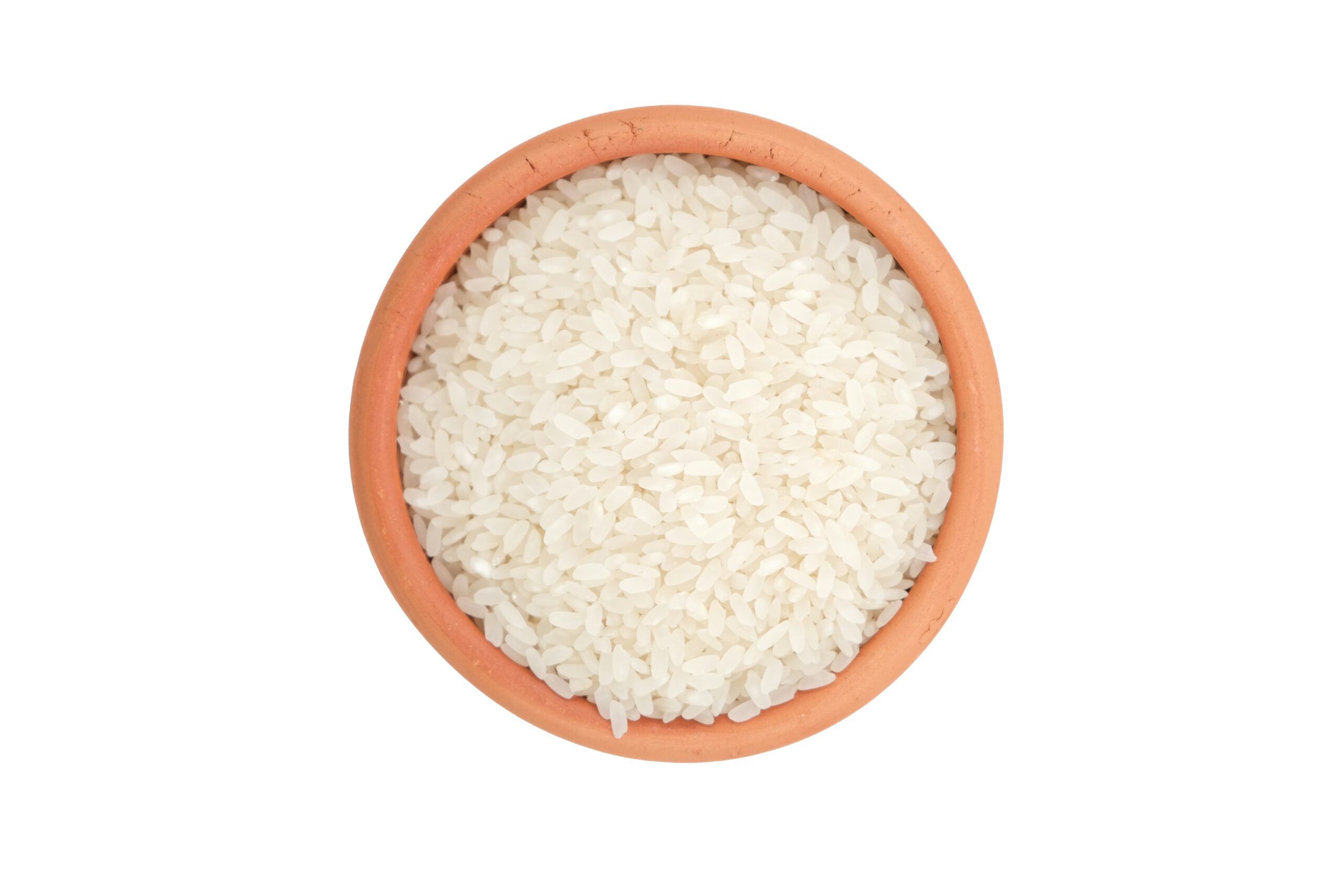 Uncooked rice in a terracotta bowl on a white background